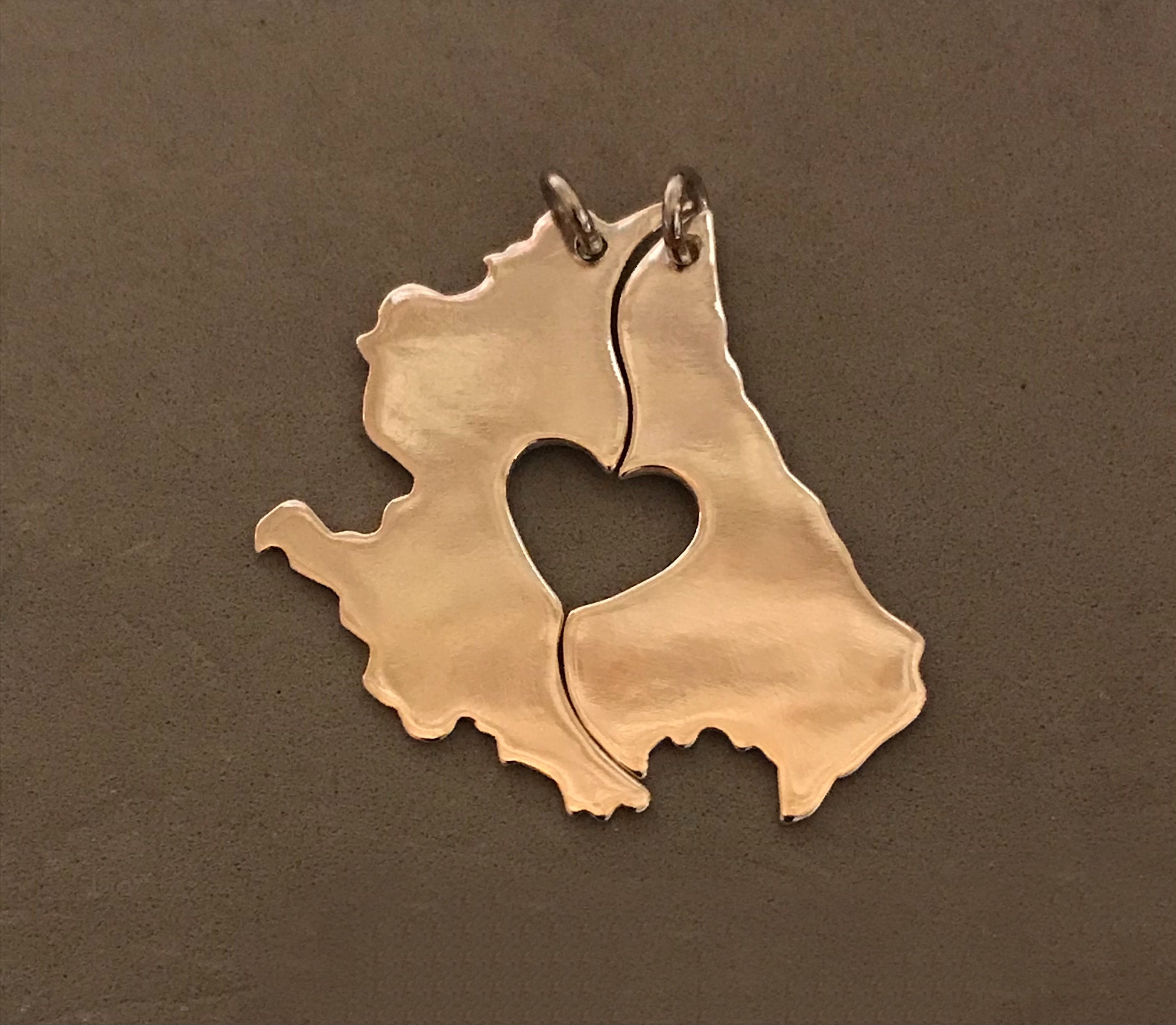 Ciondolo composto da due ciondoli a forma di Abruzzo con cuore traforato che si divide